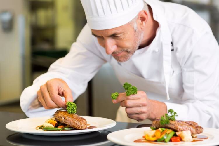 یک آشپز در حال تزیین غذا