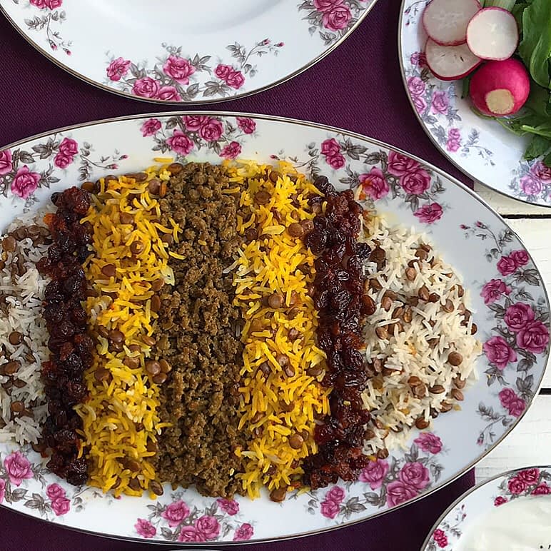 عدس پلو با تزیین برنج زعفرانی، گوشت چرخ کرده و کشمش.