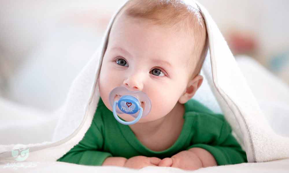 یک نوزاد در حال مکیدن پستانک