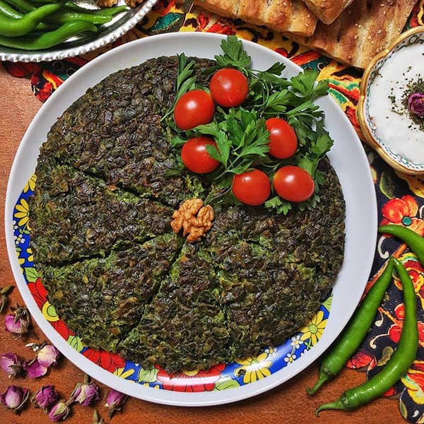 کوکو سبزی با تزیین گوجه گیلاسی و سبزی تازه