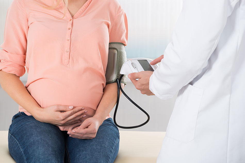یک خانم باردار درحال اندازه فشار خون خود توسط پزشک