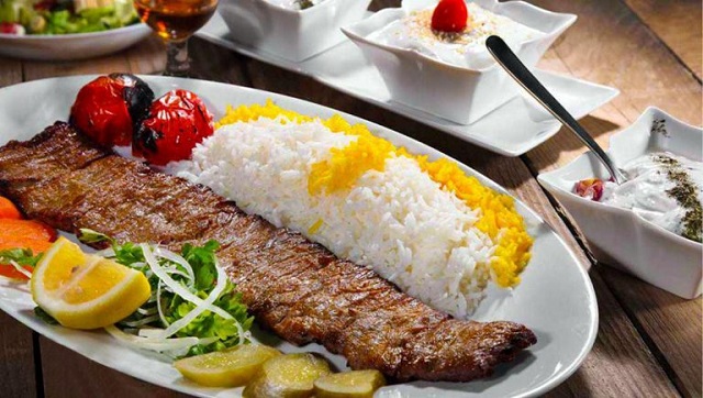 کباب برگ در کنار برنج زعفرانی و به همراه مخلفاتی همچون گوجه کبابی، سبزی، [[پیاز