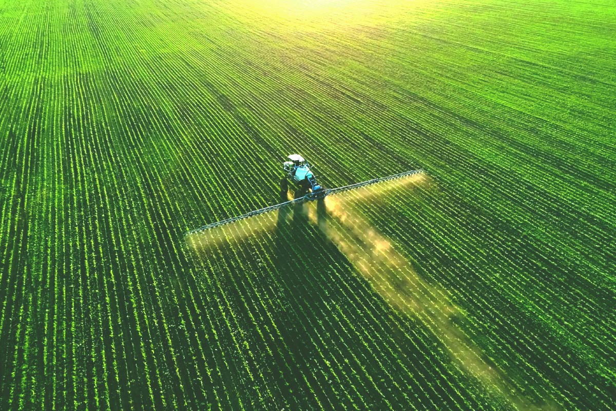 تراکتور در حال سمپاشی زمین کشاورزی