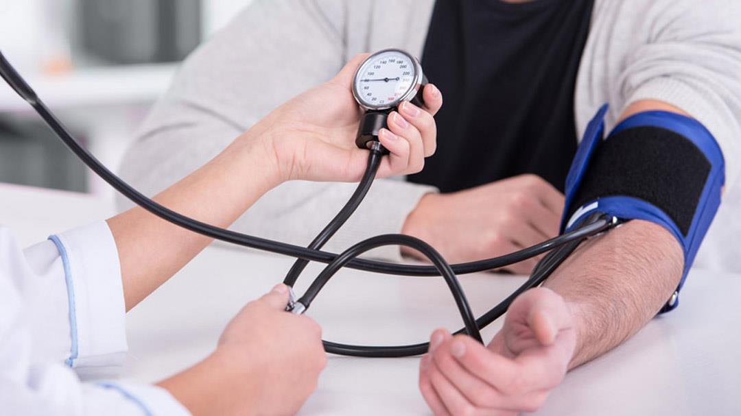 اندازهگیری فشار خون بیمار توسط پزشک به وسیلهی دستگاه فشار خون